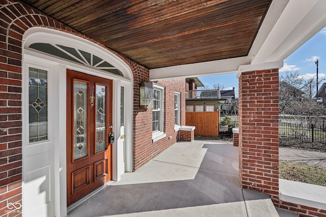 3645 N Delaware St, Indianapolis, IN 46205 - view of exterior entry with brick siding, a porch, and fence
