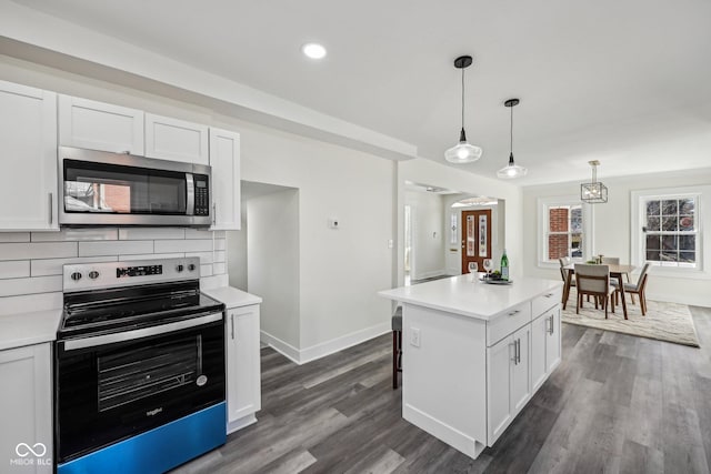 3645 N Delaware St, Indianapolis, IN 46205 - kitchen with range with electric cooktop, light countertops, white cabinets, stainless steel microwave, and backsplash