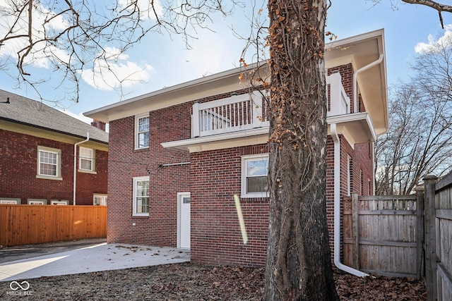 3645 N Delaware St, Indianapolis, IN 46205 - rear view of house featuring a patio, brick siding, fence private yard, and a balcony