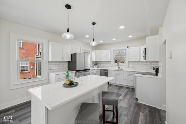 3645 N Delaware St, Indianapolis, IN 46205 - kitchen with light countertops, decorative backsplash, appliances with stainless steel finishes, white cabinetry, and dark wood-style flooring