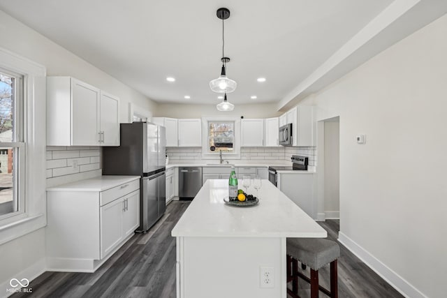 3645 N Delaware St, Indianapolis, IN 46205 - kitchen with baseboards, a kitchen island, appliances with stainless steel finishes, and white cabinets