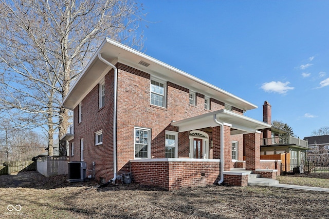 view of property exterior featuring brick siding, central AC unit, and fence