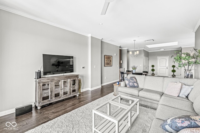 living area with an inviting chandelier, baseboards, crown molding, and wood finished floors