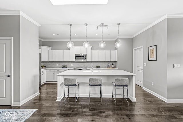 kitchen featuring a sink, a kitchen bar, stainless steel appliances, and light countertops