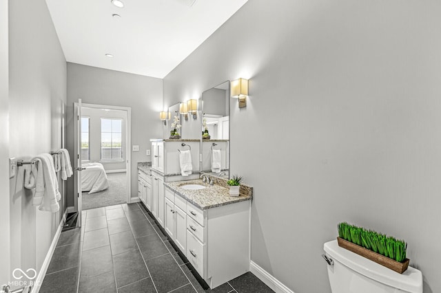 ensuite bathroom with ensuite bathroom, tile patterned floors, toilet, and baseboards