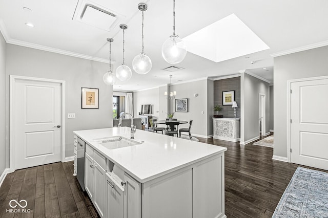 kitchen with dark wood finished floors, light countertops, visible vents, stainless steel dishwasher, and a sink