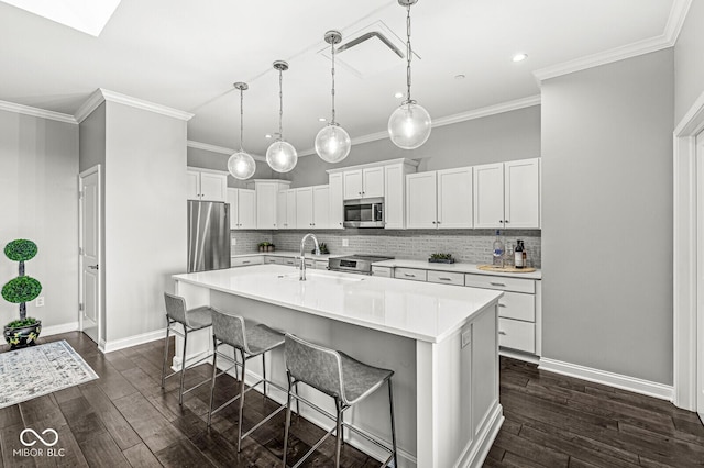 kitchen featuring a breakfast bar, appliances with stainless steel finishes, dark wood-style flooring, and a sink