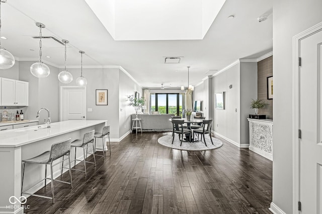 dining room featuring crown molding, visible vents, dark wood finished floors, and baseboards