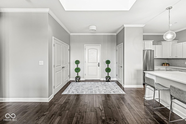 foyer featuring dark wood-style floors, a skylight, ornamental molding, and baseboards