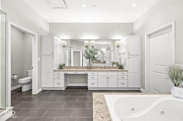 full bathroom featuring toilet, vanity, baseboards, tile patterned floors, and a whirlpool tub