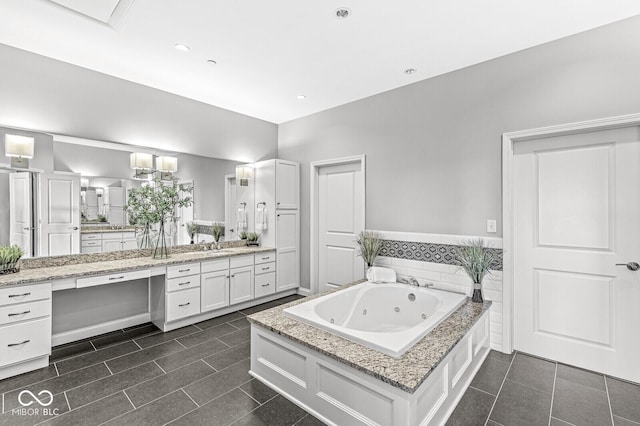 full bathroom featuring a jetted tub, tile patterned flooring, and vanity