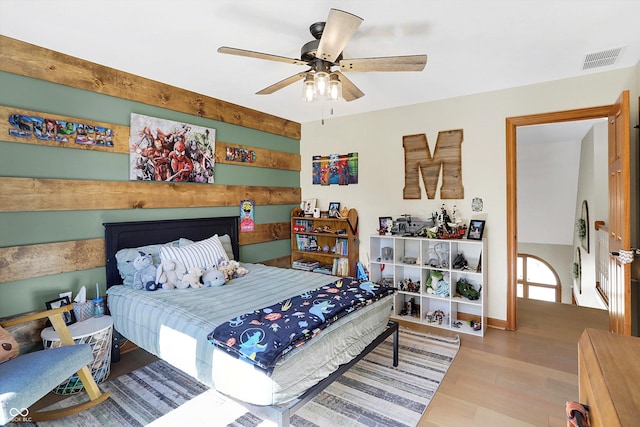 bedroom featuring ceiling fan, visible vents, and wood finished floors