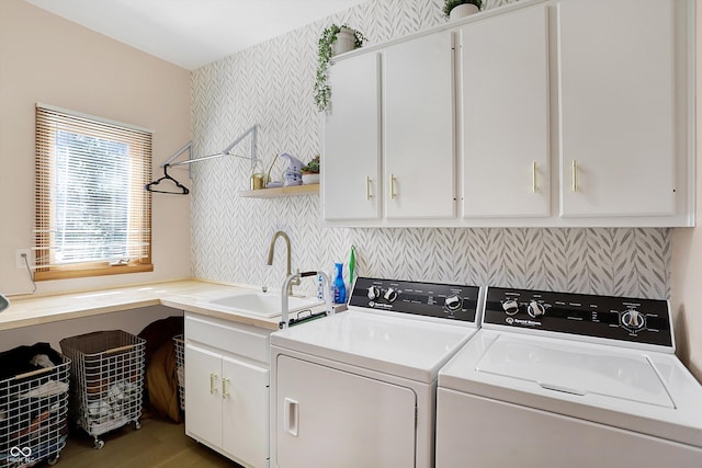 clothes washing area featuring a sink, cabinet space, wood finished floors, and washer and clothes dryer