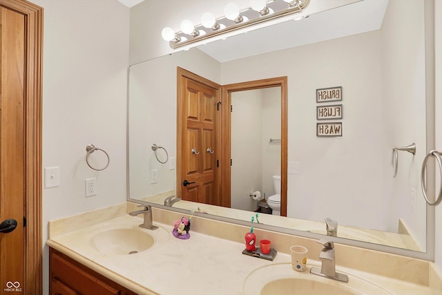 full bathroom featuring double vanity, toilet, and a sink