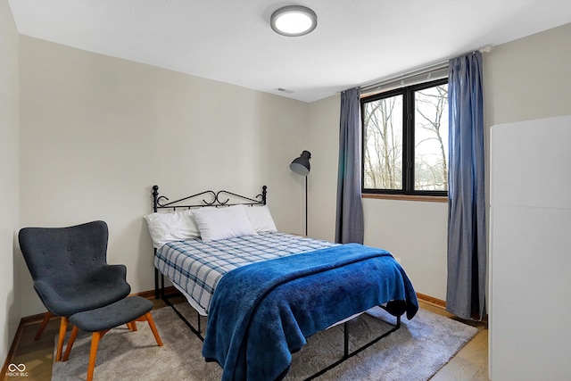 bedroom featuring baseboards and wood finished floors