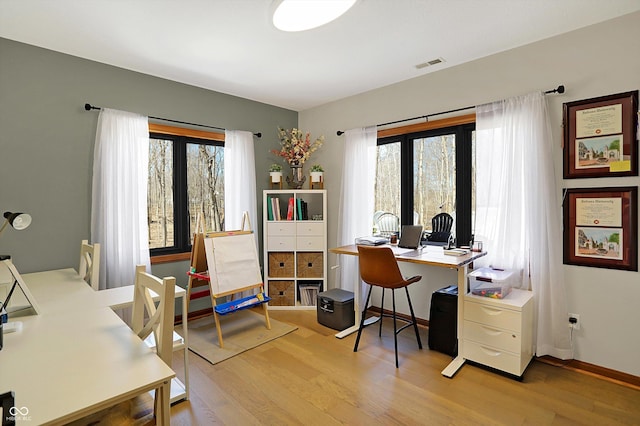 office area with visible vents, baseboards, and light wood finished floors