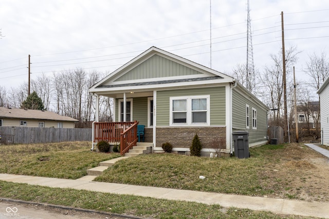 view of front of home featuring a porch, a front yard, and fence