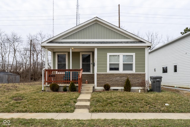 view of front of home with covered porch and a front lawn