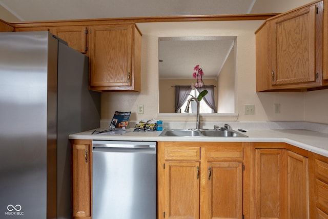 kitchen with stainless steel appliances, a sink, and light countertops