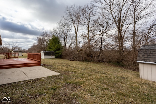 view of yard with an outdoor structure, a deck, and a storage unit