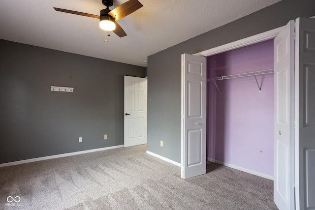 unfurnished bedroom with carpet, a textured ceiling, baseboards, and a closet