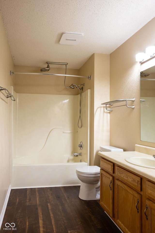 full bath featuring toilet, wood finished floors, tub / shower combination, a textured ceiling, and vanity