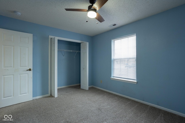 unfurnished bedroom with carpet floors, baseboards, visible vents, and a textured ceiling