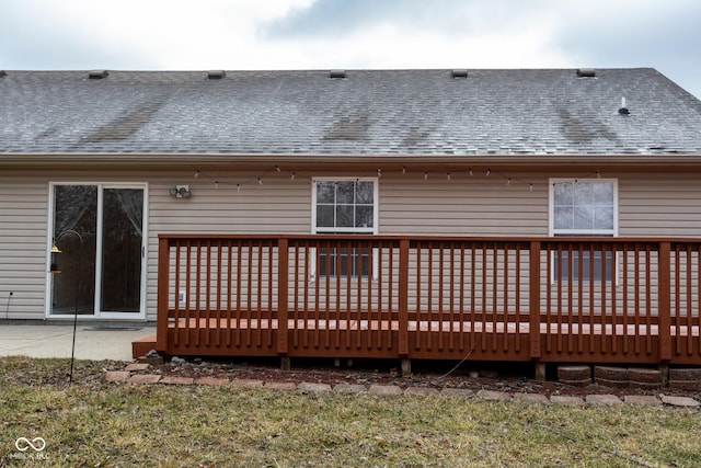 rear view of house featuring a wooden deck and roof with shingles