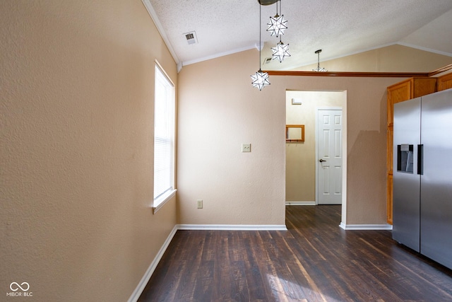 unfurnished dining area with vaulted ceiling, ornamental molding, dark wood-style flooring, and a textured ceiling