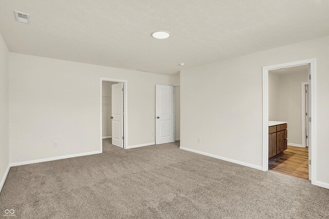 7168 Jackson Dr, Cumberland, IN 46229 - unfurnished bedroom with a spacious closet, carpet flooring, visible vents, and baseboards