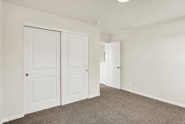 7168 Jackson Dr, Cumberland, IN 46229 - unfurnished bedroom featuring visible vents, baseboards, dark colored carpet, and a closet