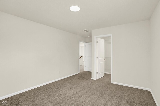7168 Jackson Dr, Cumberland, IN 46229 - unfurnished bedroom with a walk in closet, visible vents, carpet, and baseboards