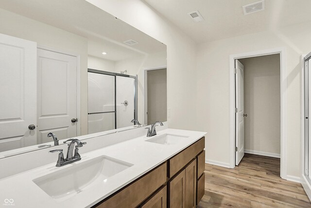 7168 Jackson Dr, Cumberland, IN 46229 - full bath featuring a shower stall, wood finished floors, visible vents, and a sink