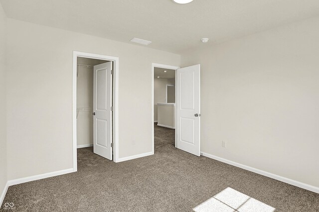 7168 Jackson Dr, Cumberland, IN 46229 - unfurnished bedroom with a spacious closet, carpet flooring, a closet, and baseboards