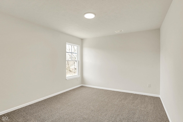 7168 Jackson Dr, Cumberland, IN 46229 - empty room featuring visible vents, baseboards, a textured ceiling, and dark carpet