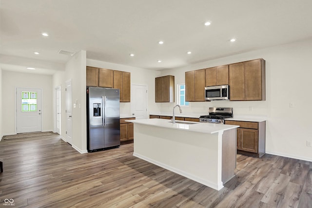 7168 Jackson Dr, Cumberland, IN 46229 - kitchen featuring wood finished floors, a center island with sink, recessed lighting, a sink, and appliances with stainless steel finishes