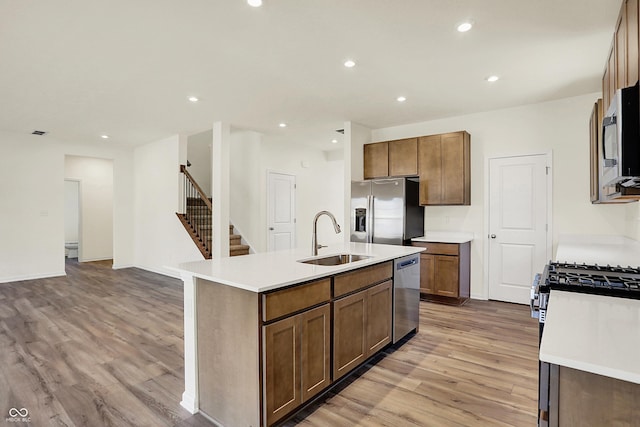 7168 Jackson Dr, Cumberland, IN 46229 - kitchen with a center island with sink, a sink, recessed lighting, stainless steel appliances, and light wood-style floors