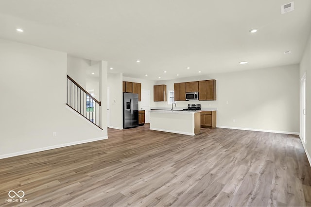 7168 Jackson Dr, Cumberland, IN 46229 - kitchen with stainless steel appliances, open floor plan, wood finished floors, light countertops, and recessed lighting