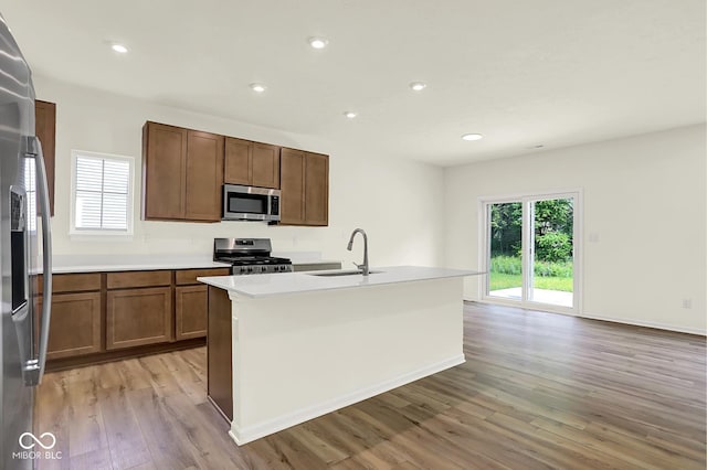 7168 Jackson Dr, Cumberland, IN 46229 - kitchen featuring stainless steel appliances, light wood-style floors, a kitchen island with sink, light countertops, and recessed lighting