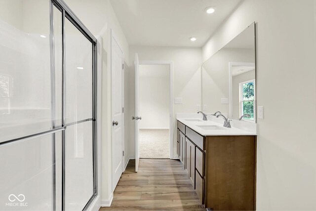 7168 Jackson Dr, Cumberland, IN 46229 - full bathroom featuring wood finished floors, double vanity, a stall shower, and recessed lighting