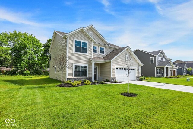 7168 Jackson Dr, Cumberland, IN 46229 - traditional home with a front yard, concrete driveway, stone siding, and an attached garage