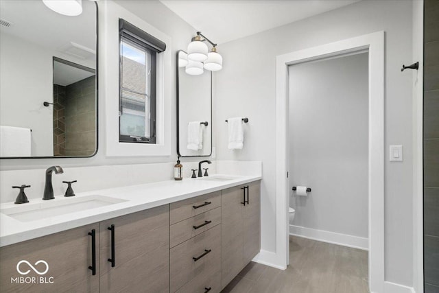 2026 Alvord St, Indianapolis, IN 46202 - full bathroom with double vanity, toilet, baseboards, and a sink