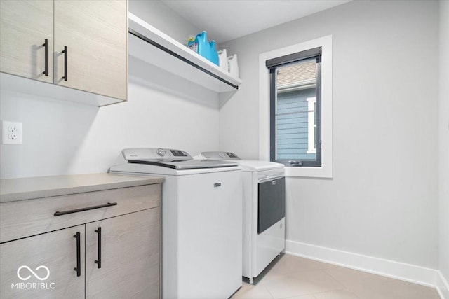 2026 Alvord St, Indianapolis, IN 46202 - laundry area with light tile patterned floors, cabinet space, independent washer and dryer, and baseboards