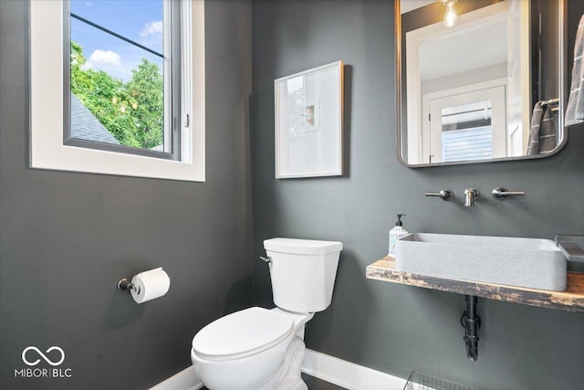 2026 Alvord St, Indianapolis, IN 46202 - half bath featuring a sink, baseboards, and toilet