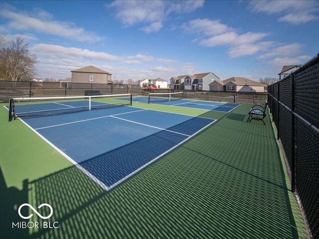 view of sport court with fence and a residential view