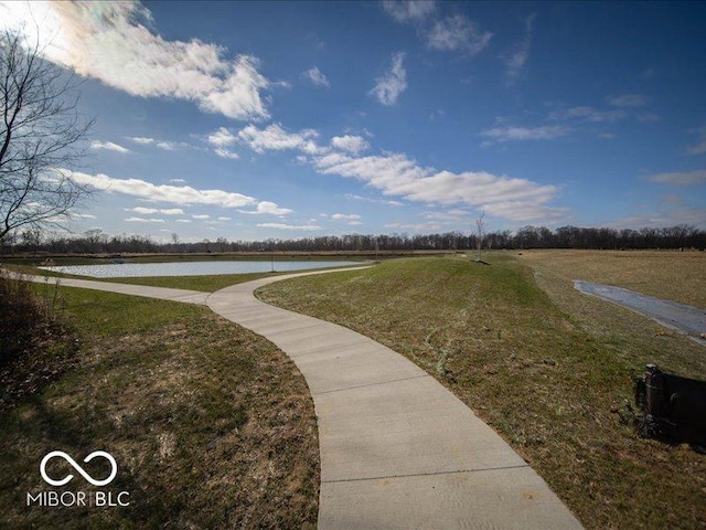 view of property's community featuring a lawn and a water view
