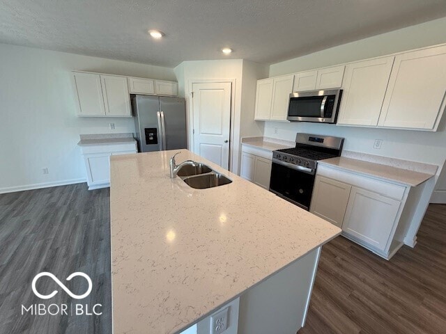 kitchen featuring dark wood-style floors, a sink, white cabinetry, and appliances with stainless steel finishes