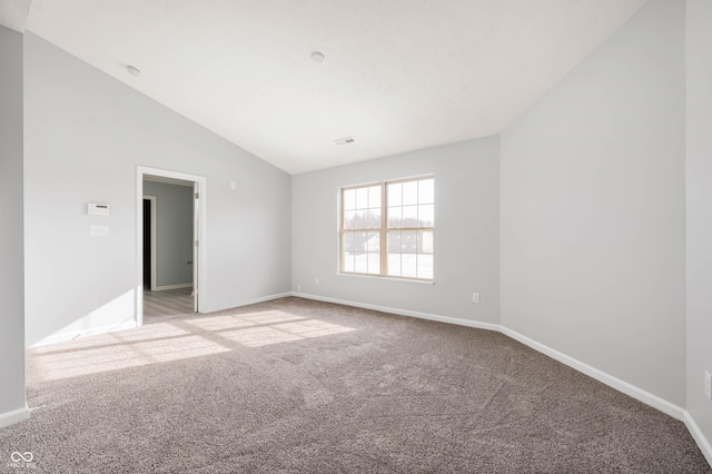 carpeted spare room with lofted ceiling, visible vents, and baseboards