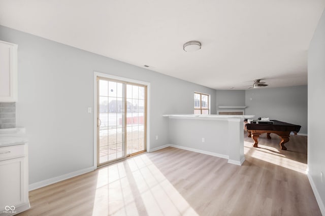 living room with a ceiling fan, visible vents, light wood-style flooring, and baseboards