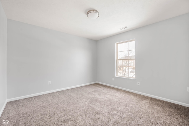 spare room featuring carpet floors, baseboards, and visible vents